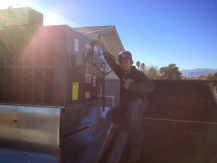 HVAC technician performing AC Tune-Up on a rooftop unit in West Donegal